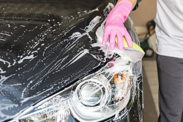 Tvättar bil med tvättsvamp