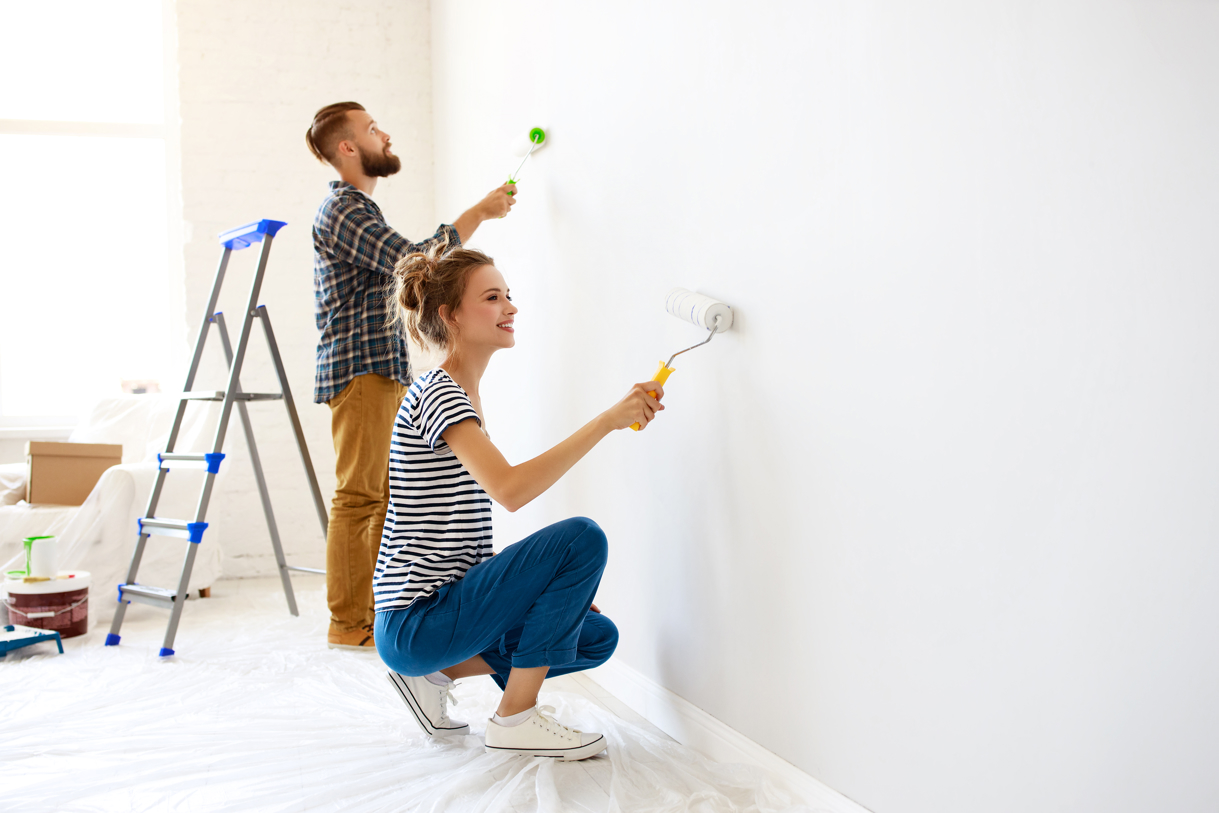 Kvinna och man vitmålar vägg
